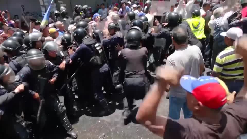 Protesters clash with police in Caracas over state worker pay | Reuters